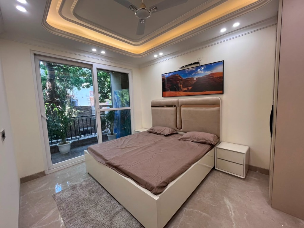 Bedroom with sliding balcony glass doors in The Nivasa II Mandi Delhi