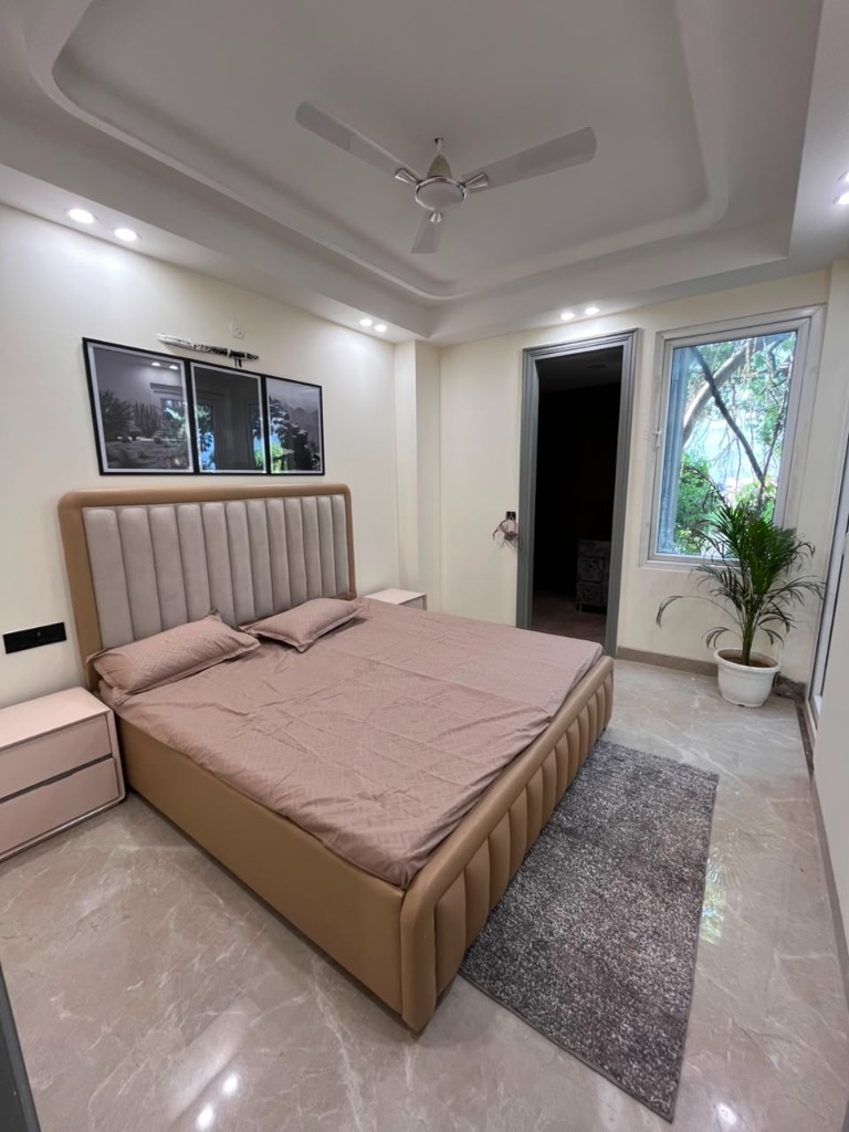 Master bedroom with upholstered headboard in 3 BHK flat Mandi New Delhi